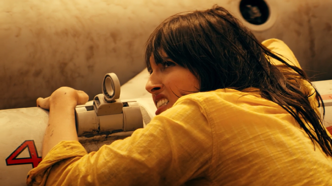 A a close up image of a woman with a yellow blouse hanging onto a small boat. She looks very scared and a bit angry.